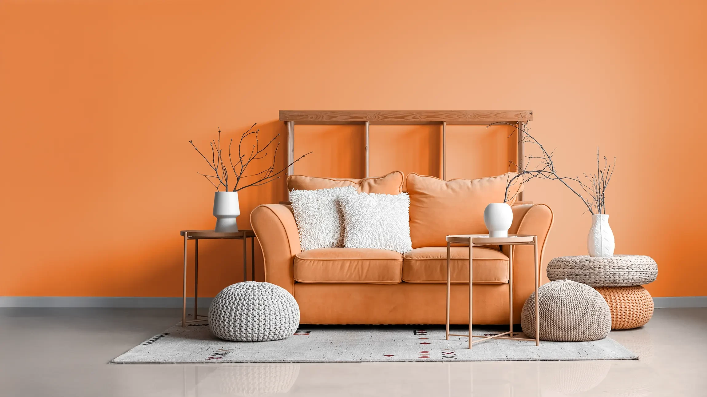 Scène d'intérieur avec deux pinceaux professionnels posés sur un nuancier de couleurs beiges et terracotta disposé en éventail. Les pinceaux présentent des manches en bois naturel et des viroles métalliques cuivrées.