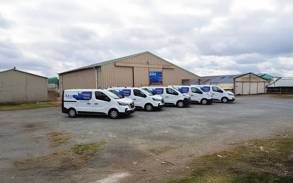 Ouvrier en train de poser du parquet en bois massif à motif chevron dans un intérieur résidentiel. L'artisan porte des gants de protection beiges et utilise un maillet en bois pour ajuster les lames. Plusieurs planches sont disposées au sol, prêtes à être installées.